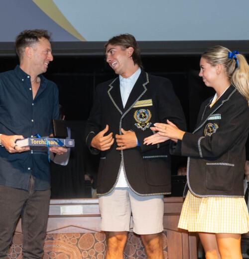 Hugh accepting the Carey Medal from 2024 School Captains, Zara and Luke.