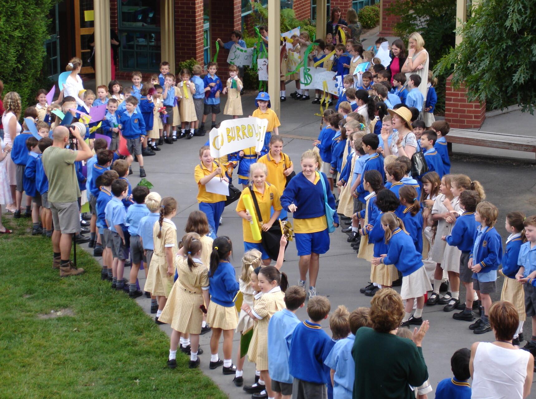 Preps, Year 1s and Year 2s form a guard of honour to see off the upper Junior School Kew House Swimming competitors in 2005.
