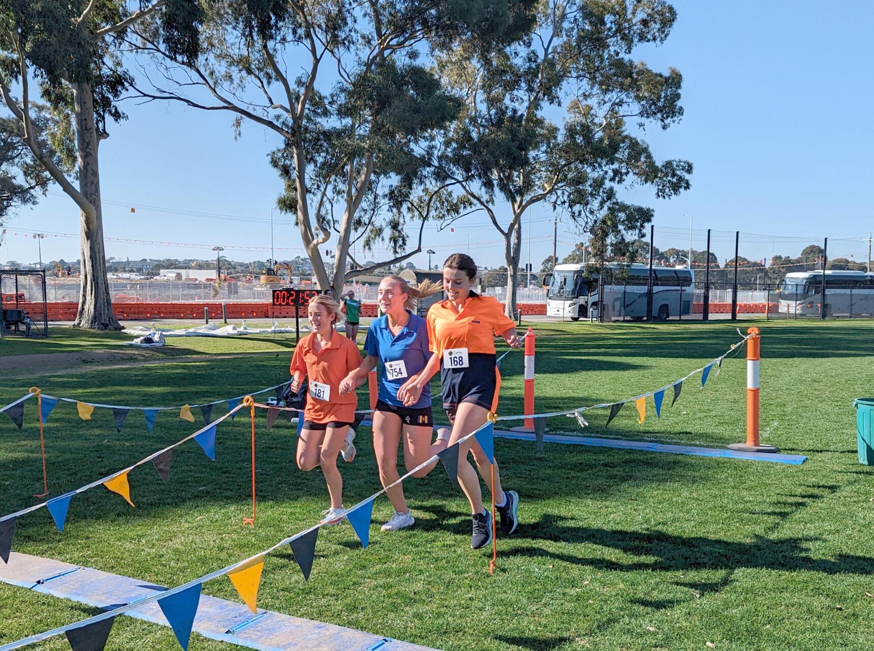 Three students cross the finish line hand-in-hand at the 2023 Senior School House Cross Country.